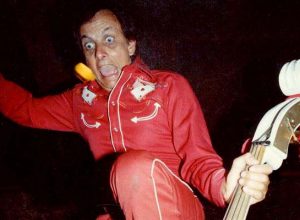 Ray Campi in red suit standing on his white double bass